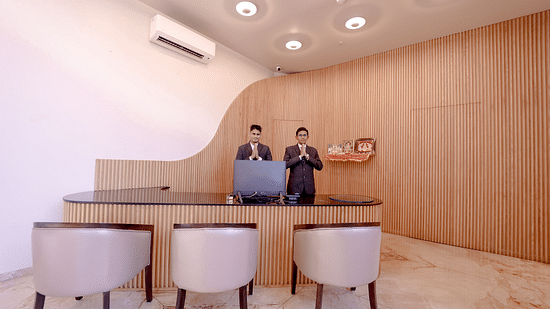 An image of two receptionist with joined hands as a way to greet their guests at Pride Resort Ambaji